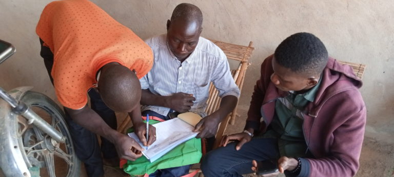 farmers fill in data on paper sheet and mobile phone